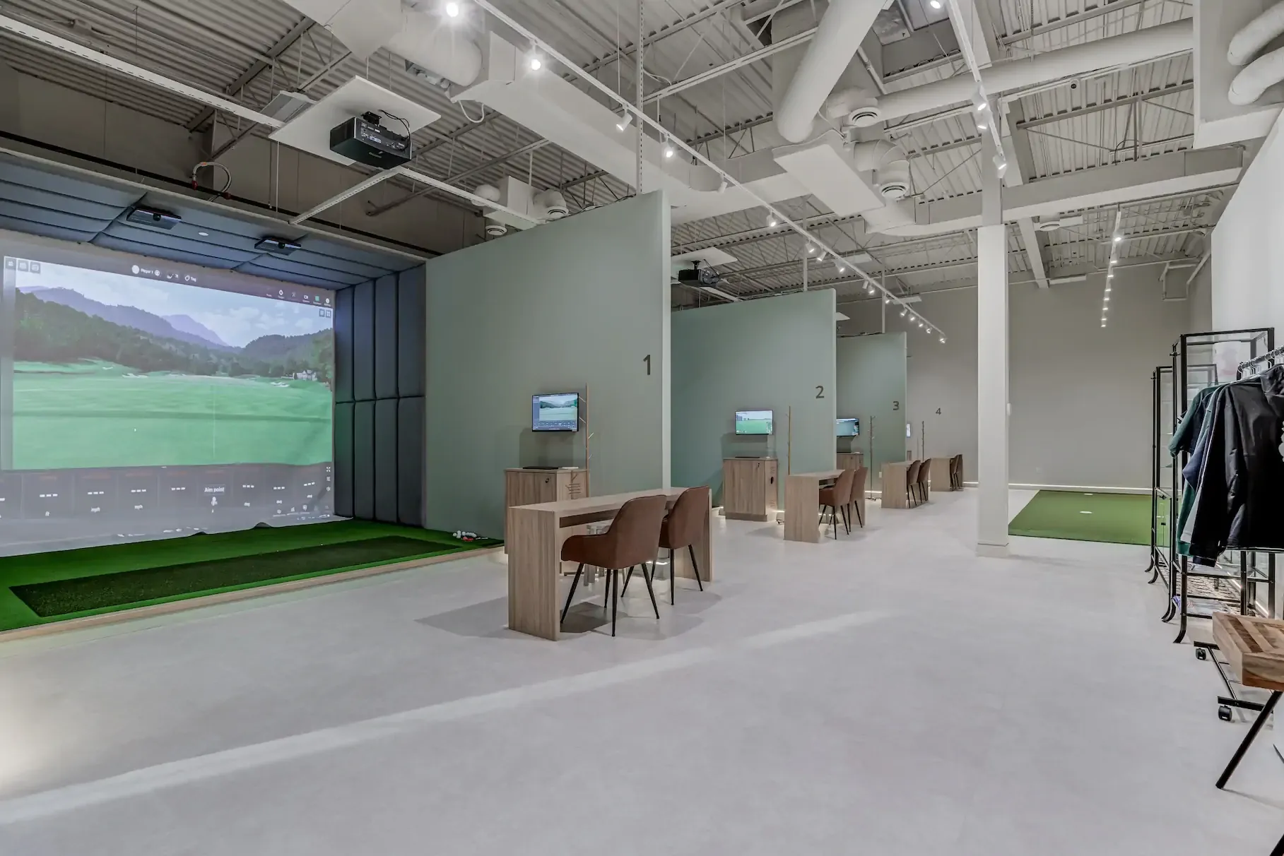 The open bays at AK Golf Studio, each with a Trackman simulator