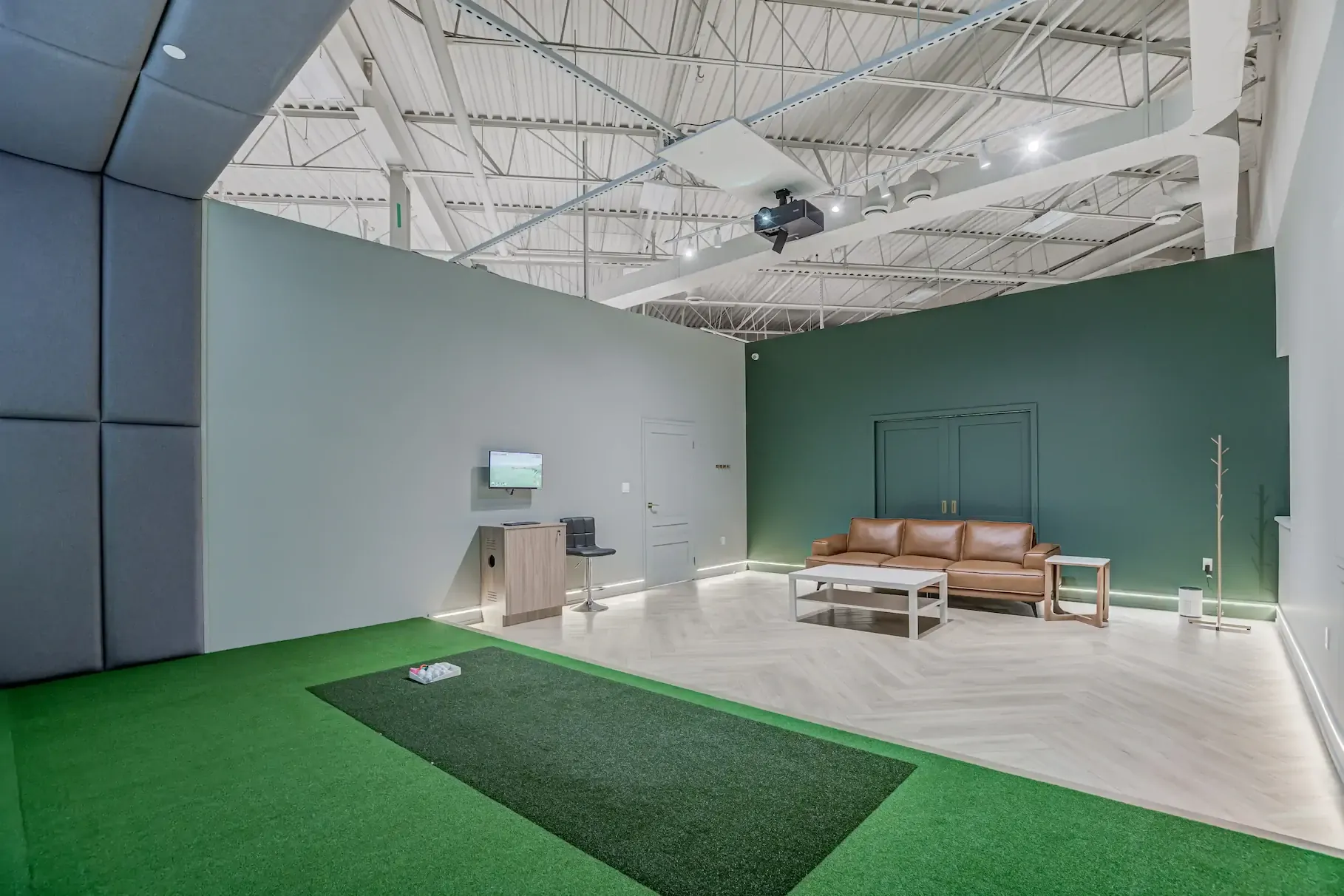 A private bay with a lounge area and hitting mat